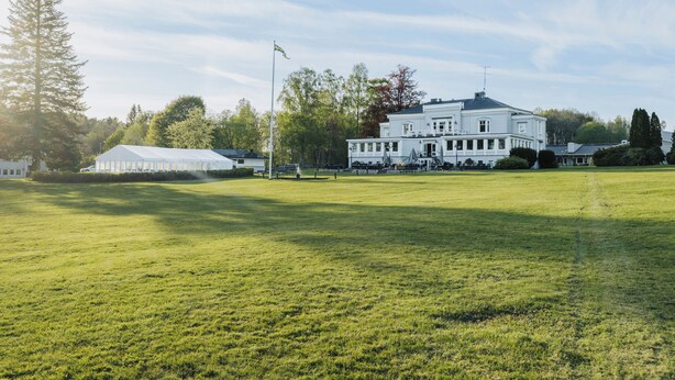 A large white building with a symmetrical facade, a flagpole, and a well-maintained lawn. - Aspenäs Herrgård (Lerum)