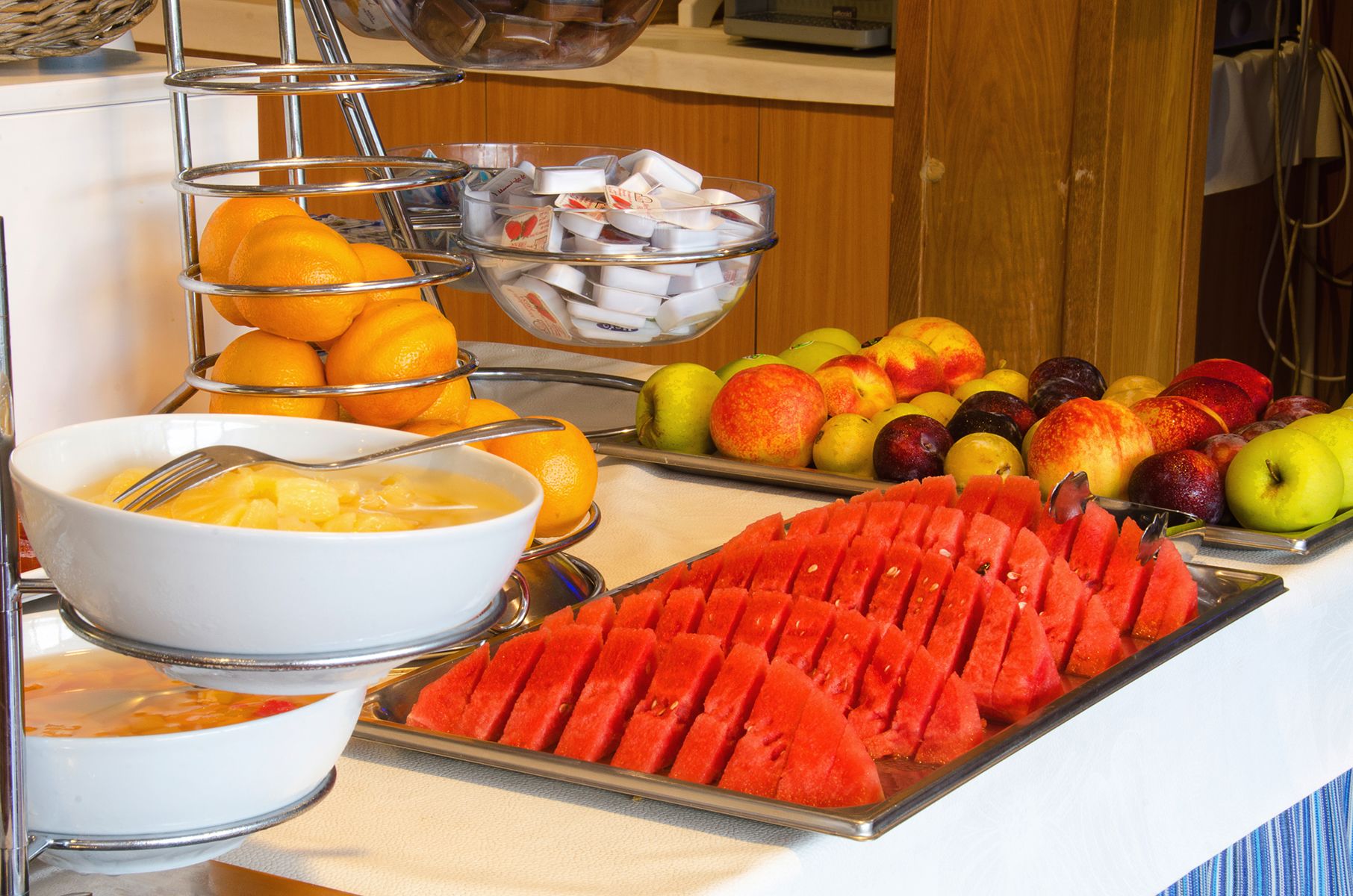 A buffet with fruits and a bowl of soup.