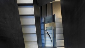 Een moderne architecturale ruimte met een geometrisch ontwerp, met een centrale glazen constructie en contrasterende wandpanelen.