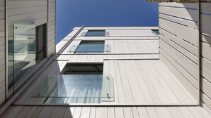 Een modern gebouw met een stenen gevel en grote ramen.
