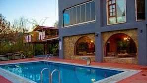 A modern building with a swimming pool, stone facade, and large windows. - Kaltur Boutique Otel (Yalova)
