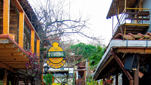A narrow street with a sign for 'TUBORG Copenhagen Denmark' leading to a building with a wooden facade and a staircase. - Kaltur Boutique Otel (Yalova)