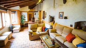 A cozy living room with two sofas, a coffee table, and a fireplace. - Casa Rural & Spa La Graja (Chinchon)