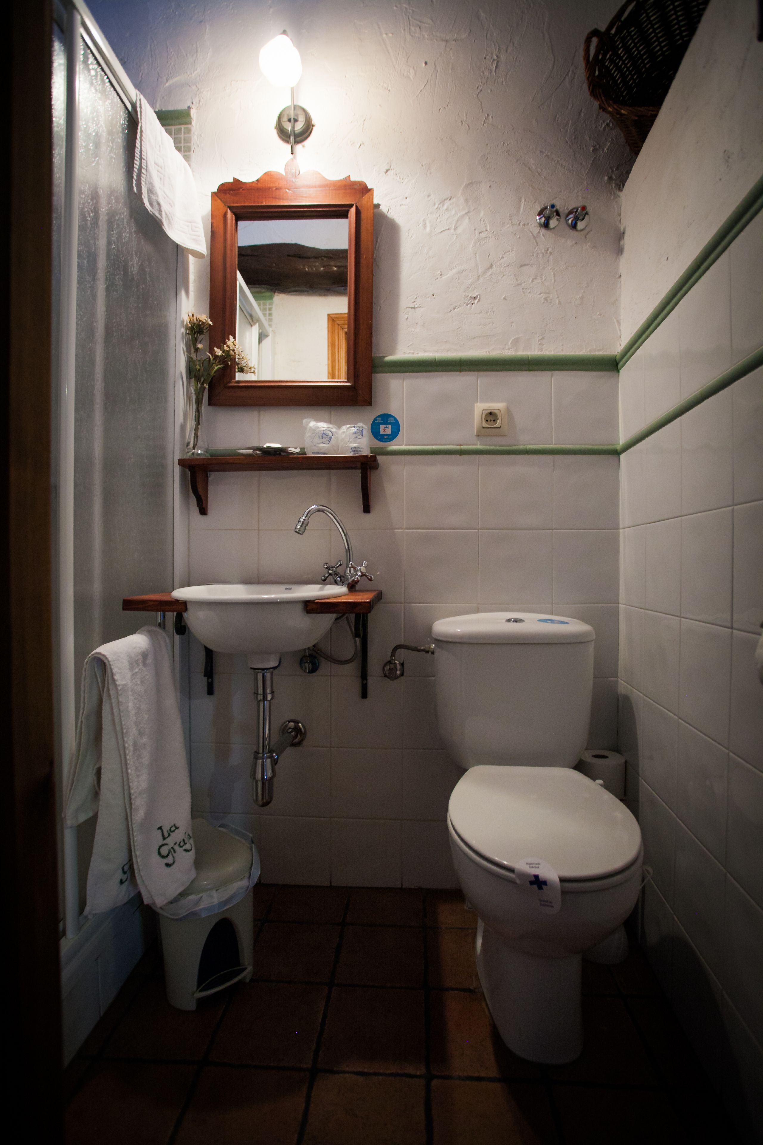 A small bathroom with a sink, toilet, and mirror.