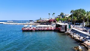 A waterfront restaurant with outdoor seating, a dock, and a view of the sea. - Veltur Turiya Hotel (Bodrum)