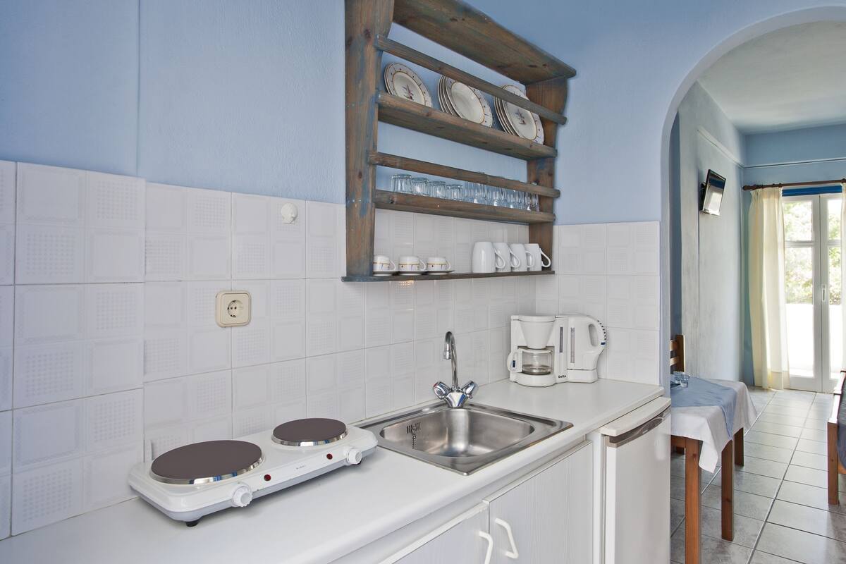 A kitchen with a built-in stove, a sink, and a coffee maker.