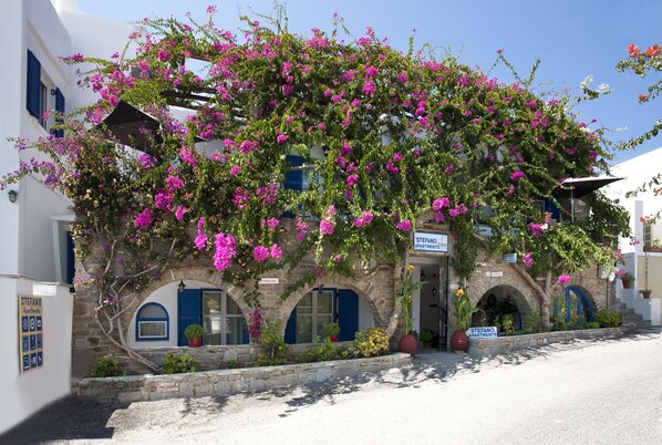 A building with arched windows and a sign for "Stefano Apartments". - Stefano Apartments (Paros)