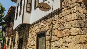 A building with a stone facade and a sign that reads "Vinova." - The Ninova (Antalya)