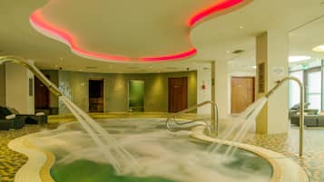 A spa area with a hot tub, seating area, and a tiled floor.