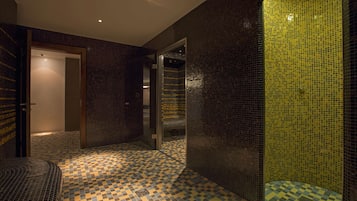 Bathroom features a large mirror, sink, and shower area with a checkered tile floor and walls.