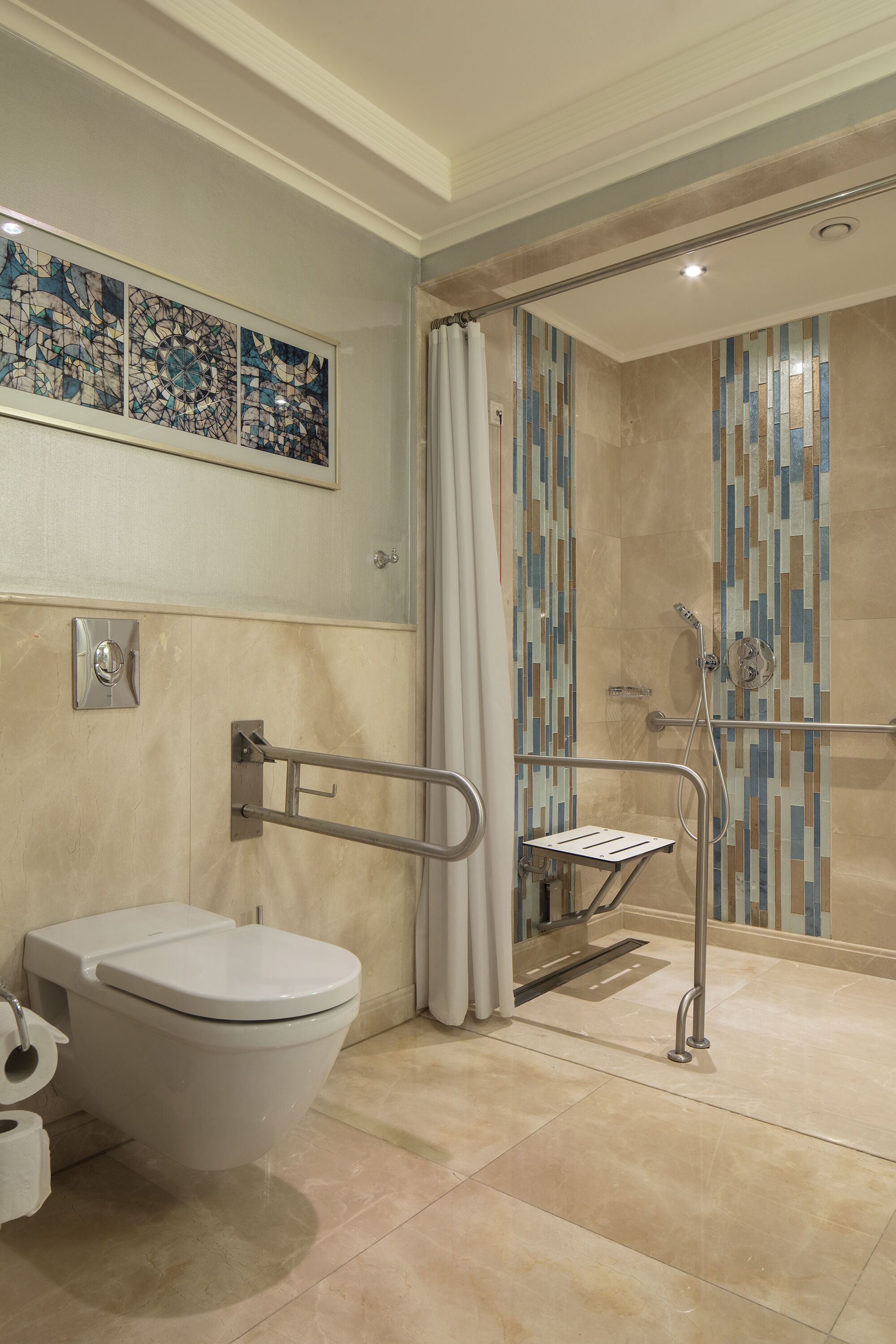 A bathroom with a toilet, a shower with a handrail, and a wall-mounted sink.