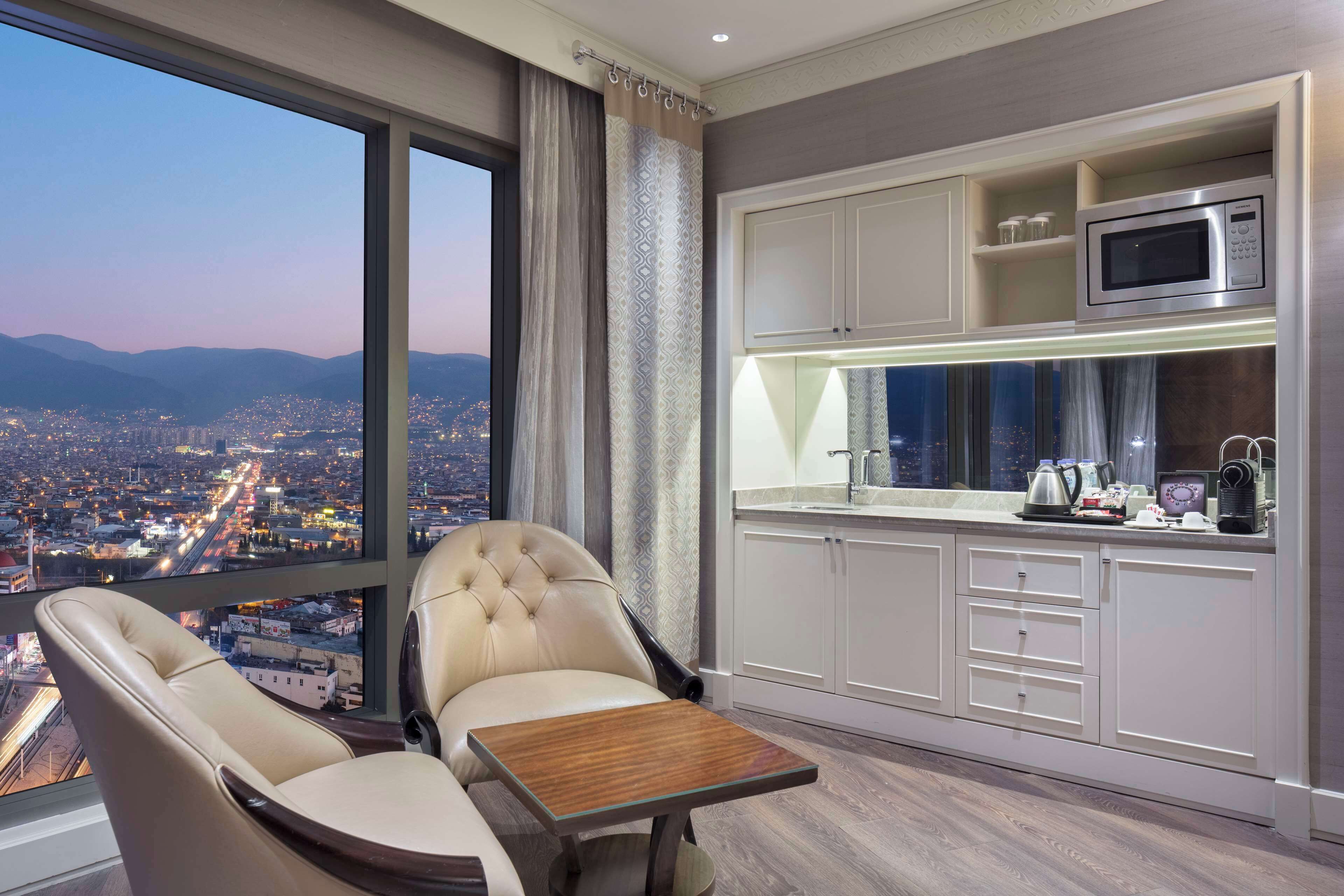Una habitación moderna con vistas a la ciudad, un comedor y una kitchenette.