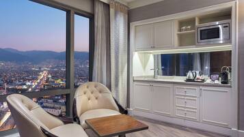 Una habitación moderna con vistas a la ciudad, un comedor y una kitchenette.