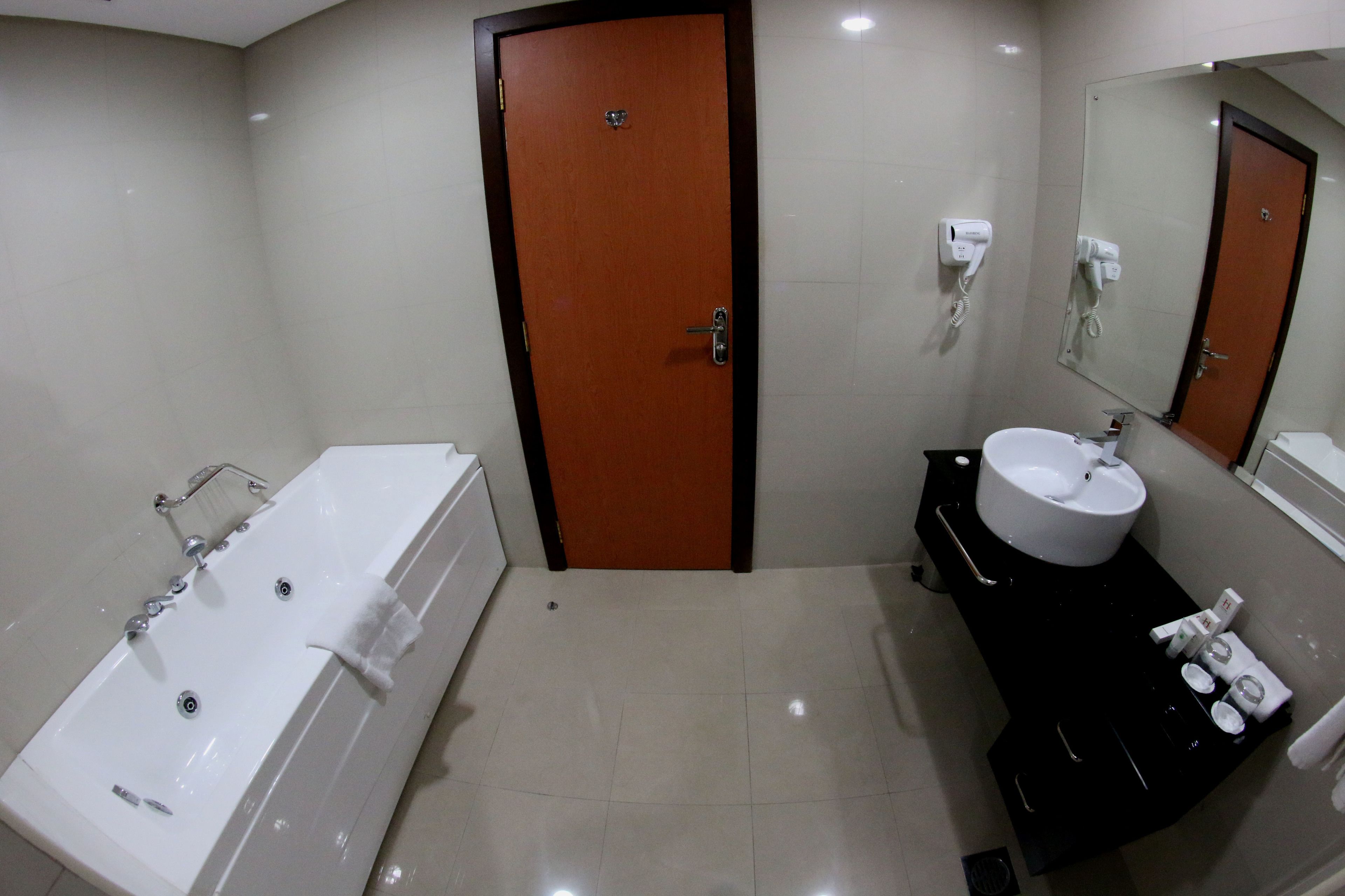 A bathroom with a bathtub, a sink, and a mirror.