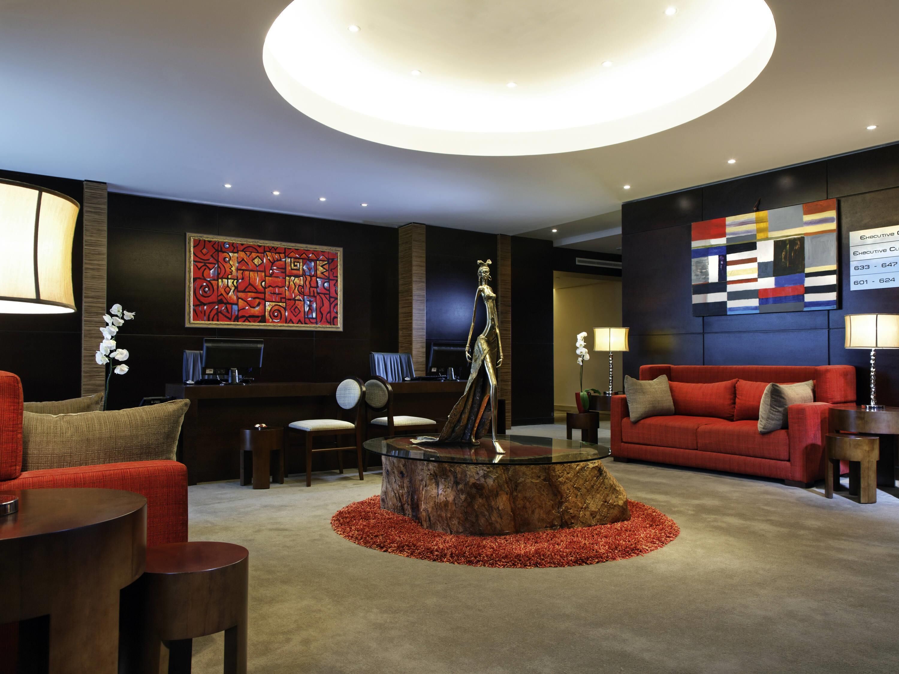 En moderne lobby med reception, siddeområde og kunstværker.