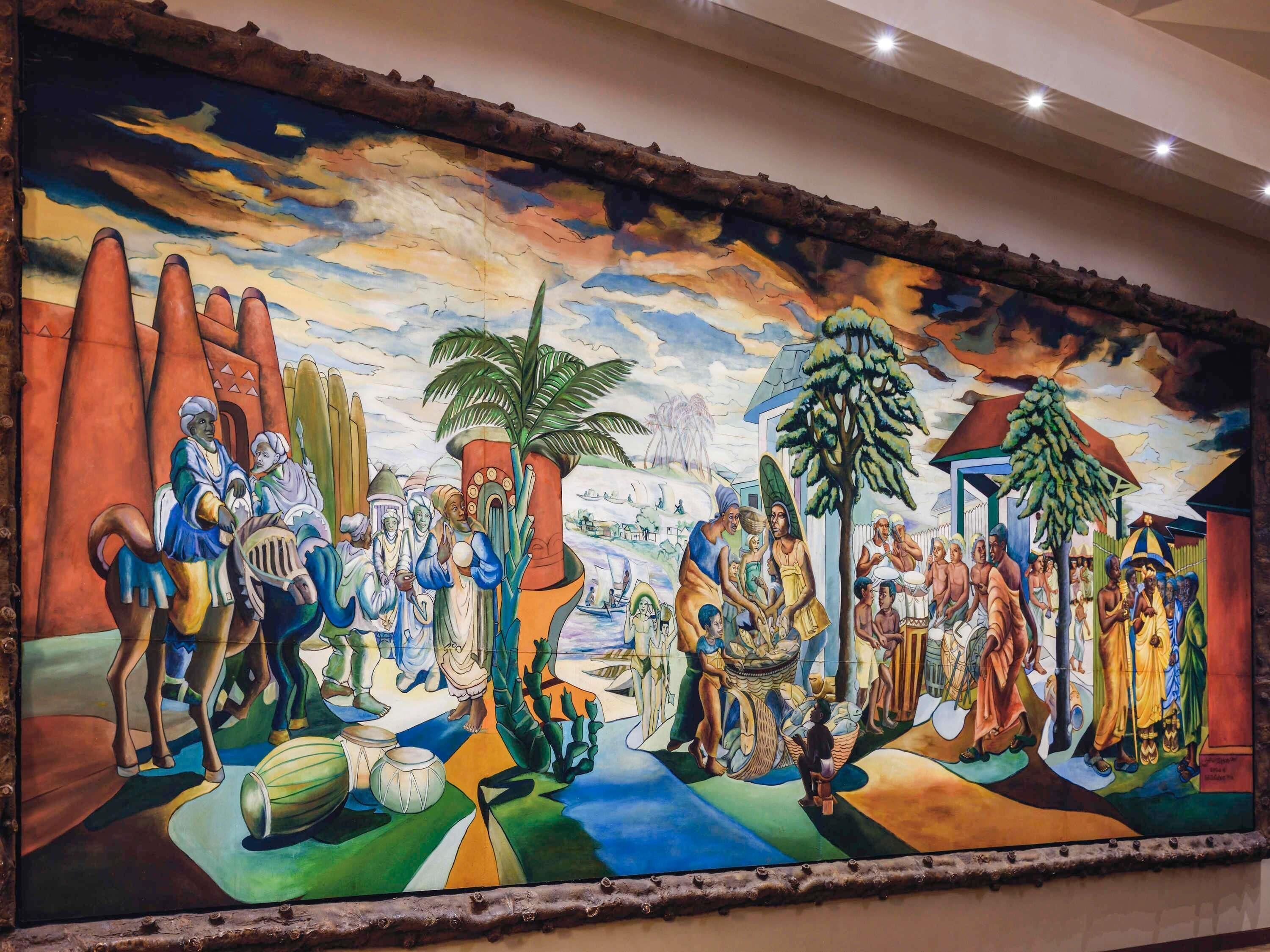 A mural with various figures and objects, including a large tree, a palm, and people in traditional attire.