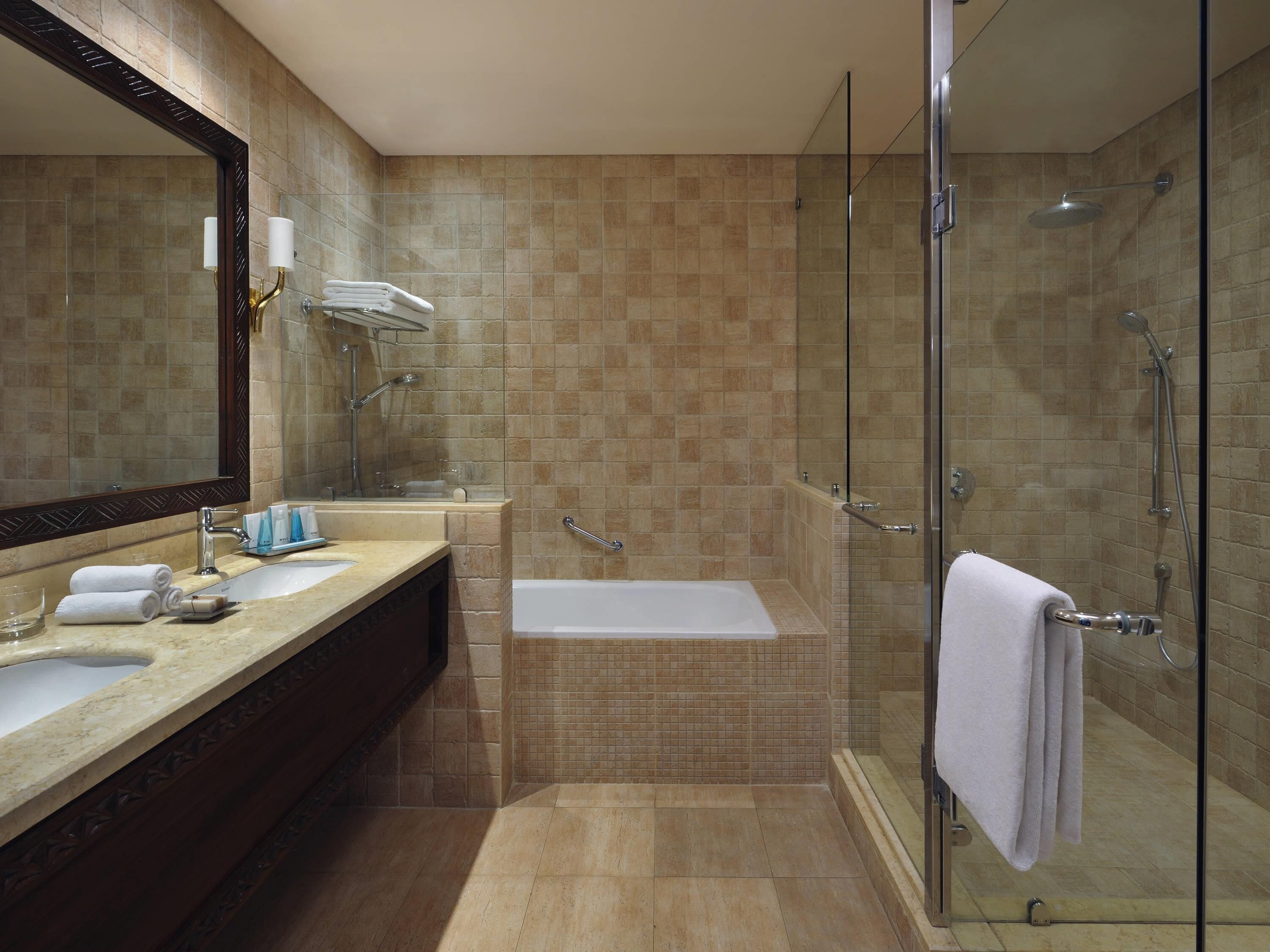 A modern bathroom with a glass-enclosed shower, a bathtub, and a vanity with a mirror and towel rack.