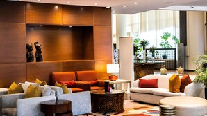 A modern lobby with seating areas, a coffee table, and decorative items. - Mövenpick Ambassador Hotel Accra (Accra)