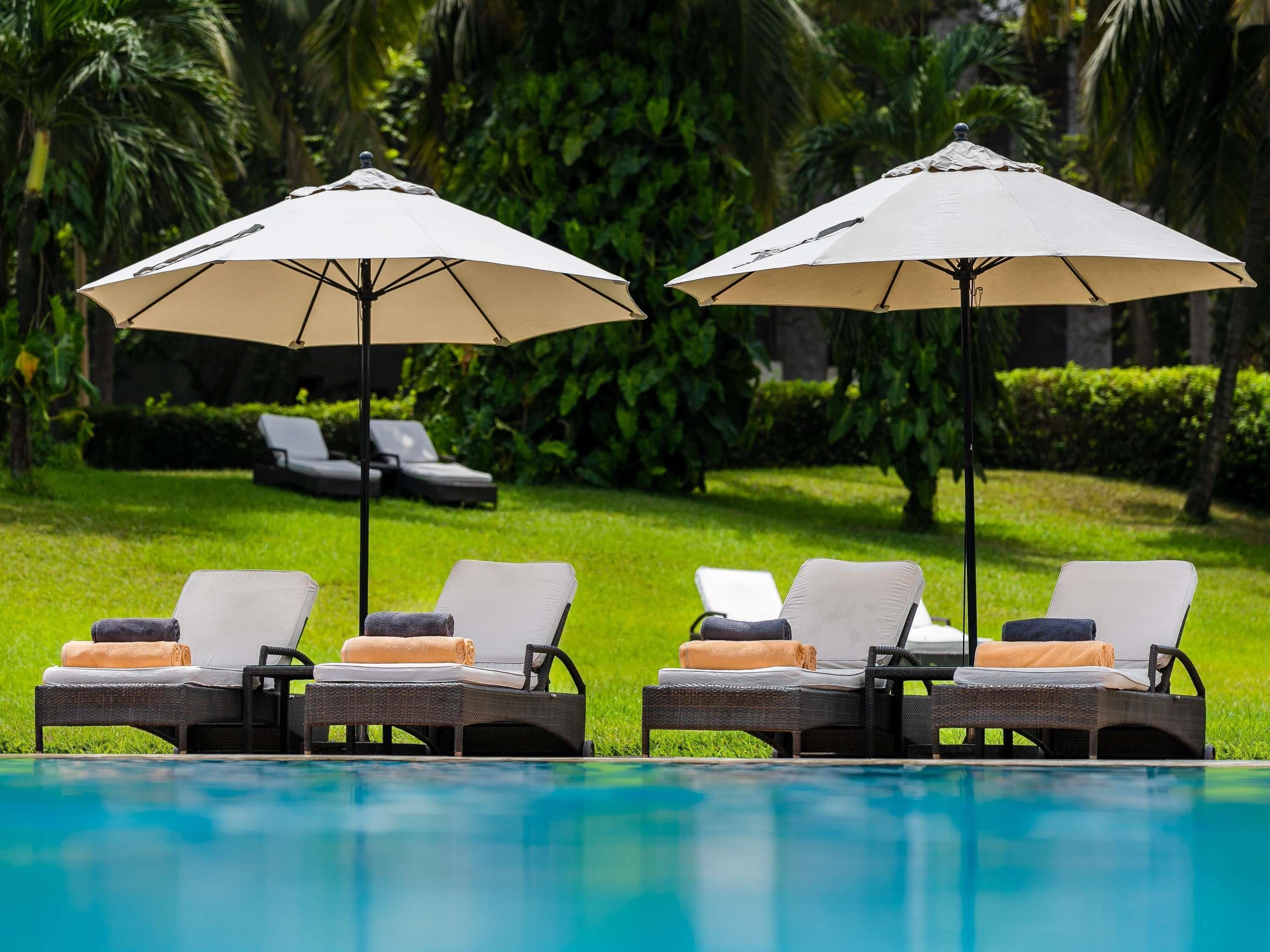 A poolside area with lounge chairs and umbrellas.