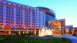 A large hotel with multiple floors, a central fountain, and a well-lit entrance area. - Mövenpick Ambassador Hotel Accra (Accra)