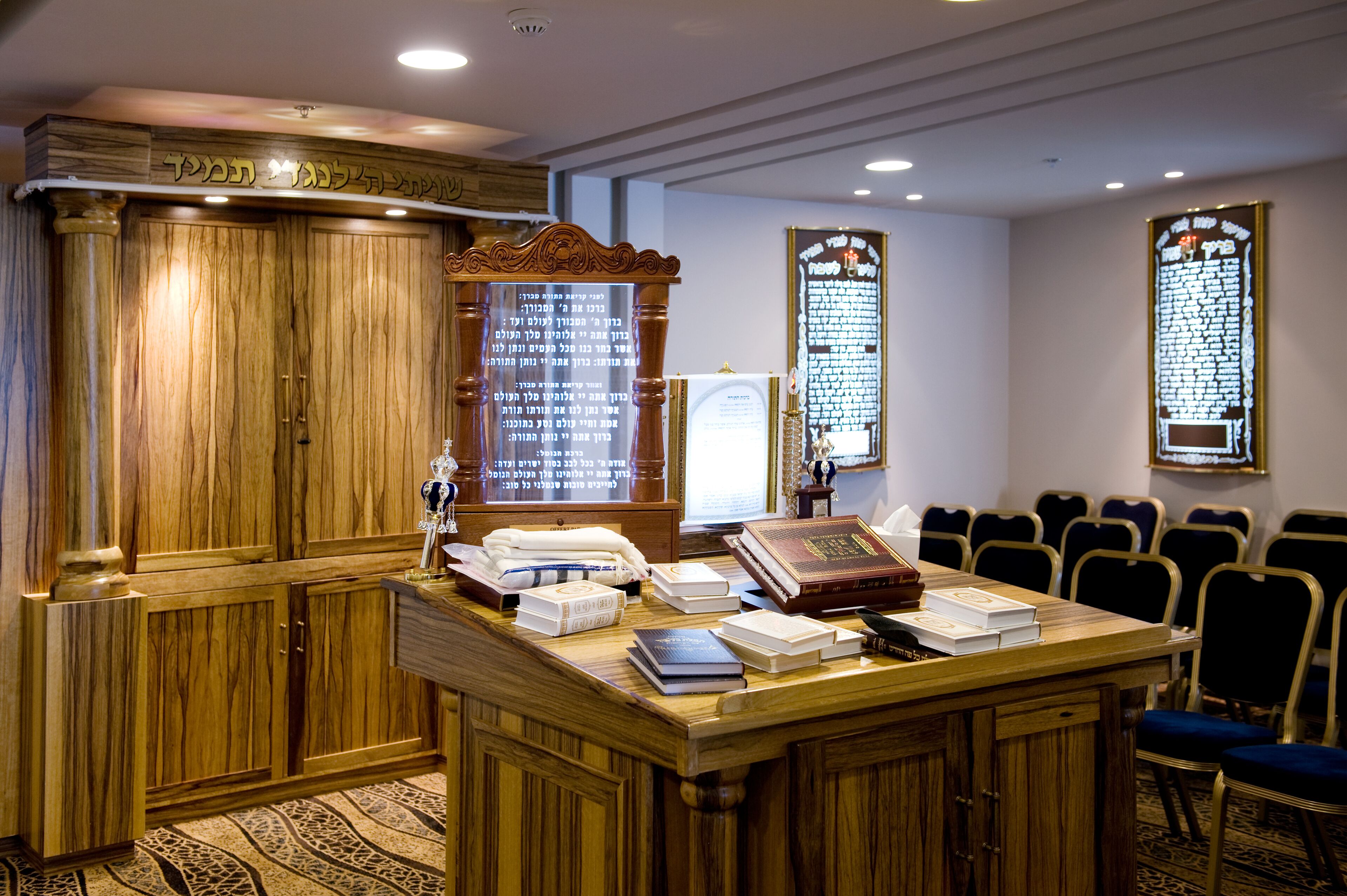 Un salón de conferencias con mobiliario de madera, un atril y una gran pizarra.
