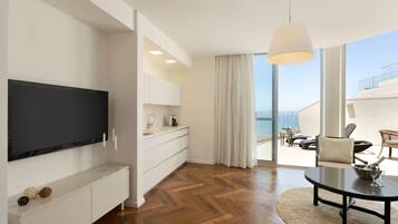 Sala de estar moderna com televisão de tela plana, console branco, mesa de centro redonda e vista para a varanda.