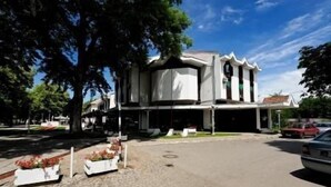 Un edificio con fachada simétrica, ventanas grandes y una entrada central.
