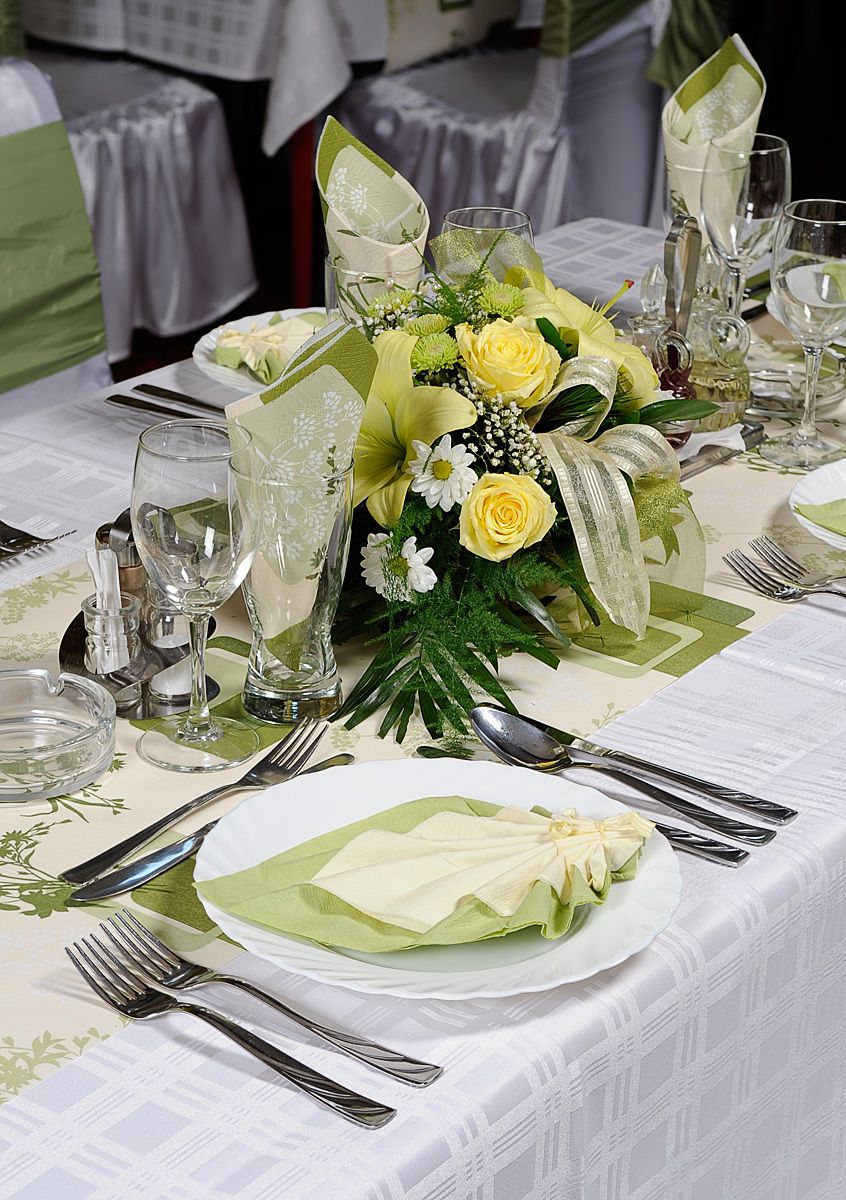 Una mesa dispuesta para un evento formal, con un centro de mesa, cristalería y cubertería.