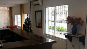 Una cocina moderna con una isla central, un árbol de Navidad y un ventanal con rejas.