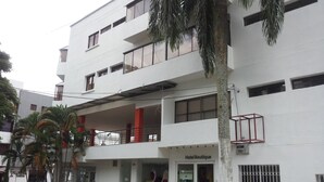 Un edificio blanco con un hotel boutique en la planta baja y pisos superiores con balcones.