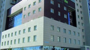 A hotel with a modern design, featuring a prominent 'Oasis Inn' sign on the facade.