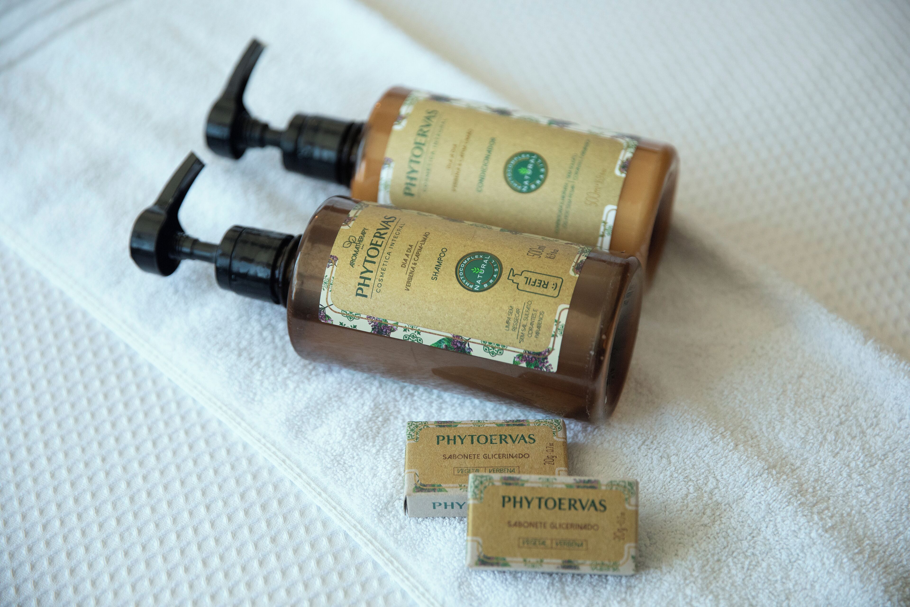 Two bottles of PHYTOERVAS shampoo and a smaller box on a white textured surface.