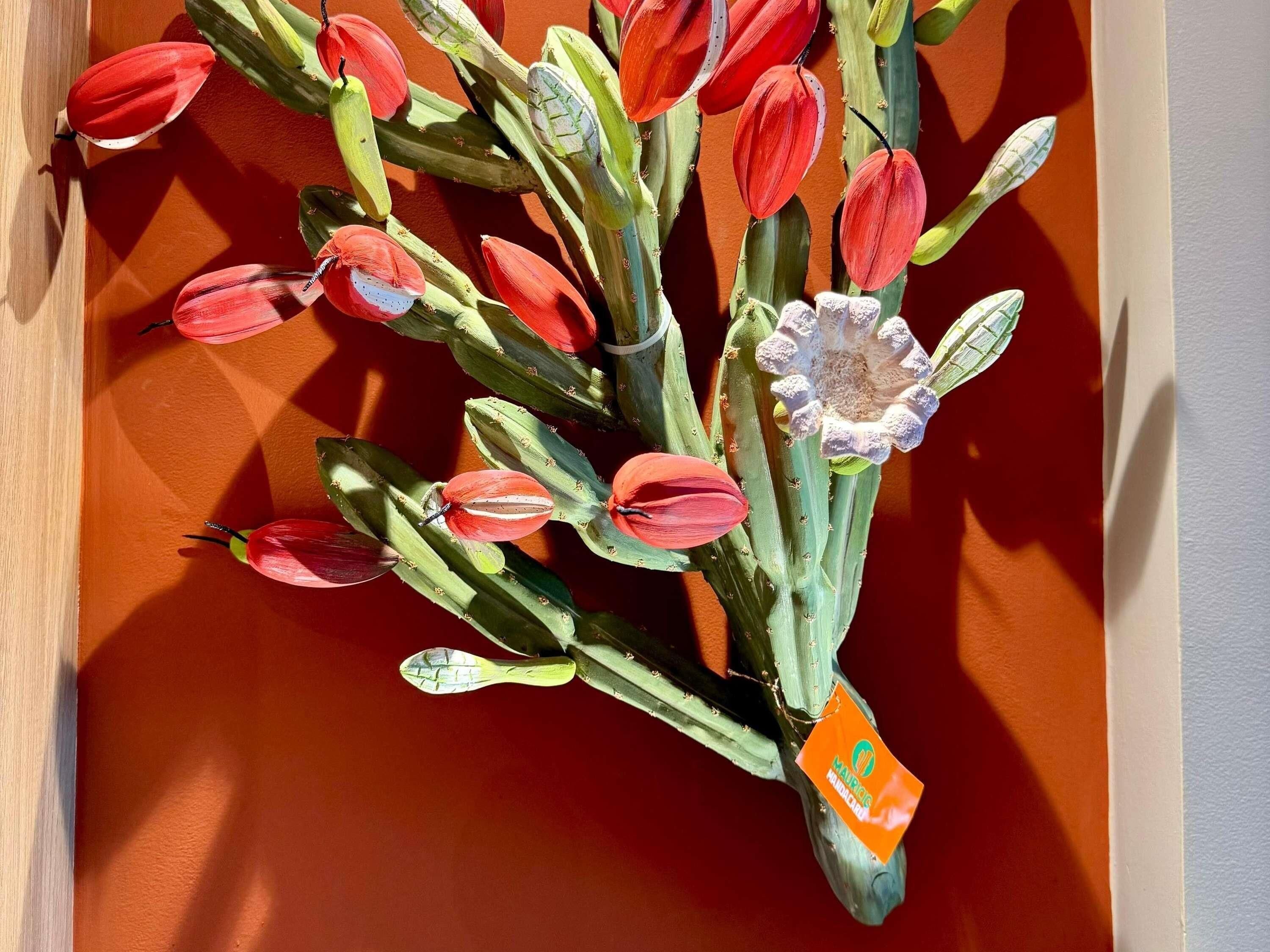 Een boeket kunstbloemen met een tag, geplaatst tegen een houten oppervlak.