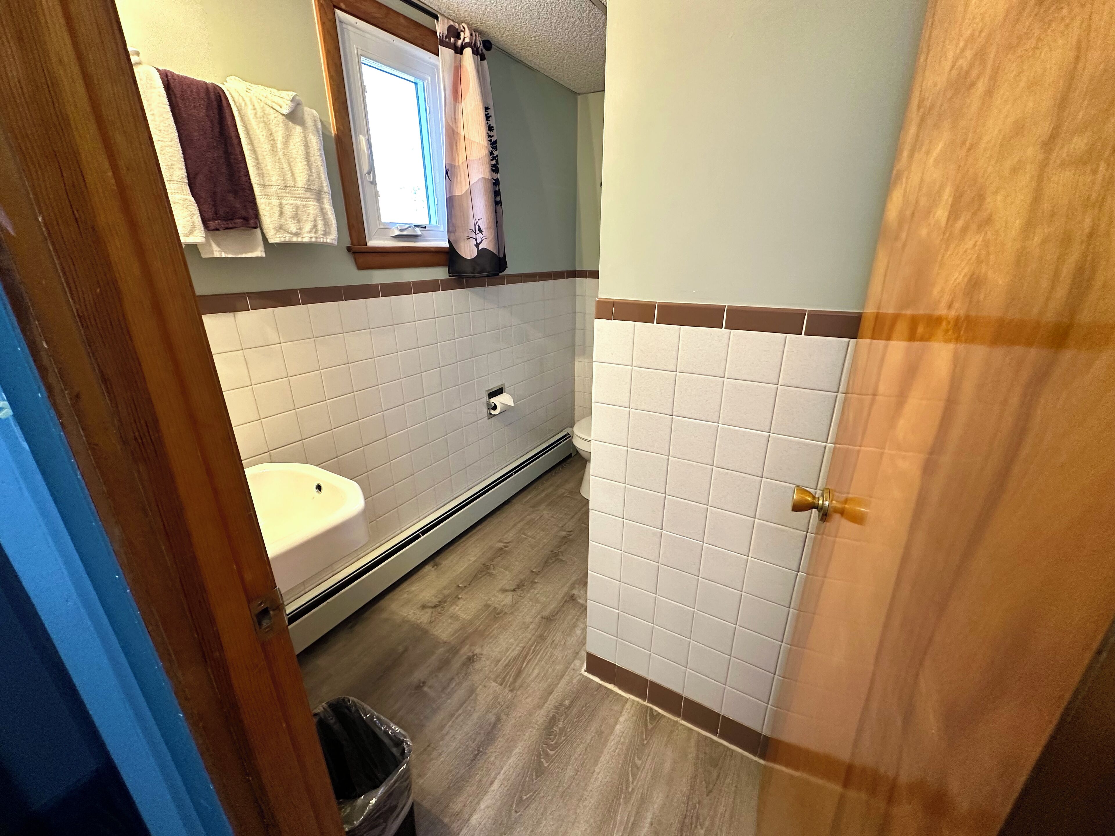 A bathroom with a white sink, a toilet, and a shower area.