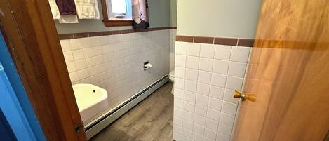 A bathroom with a white sink, a toilet, and a shower area.