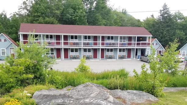 Un edificio de dos pisos con techo rojo y varios balcones.