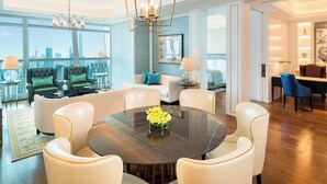 Un salon moderne avec une table à manger ronde, des fauteuils en cuir et un lustre.