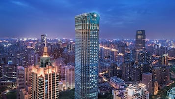 A high-rise building with a distinctive curved top, surrounded by other tall buildings in a densely populated urban area.