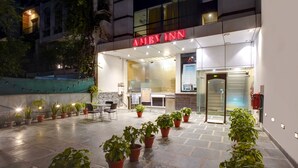 An outdoor area with a restaurant named "AMBY INN" and several potted plants.