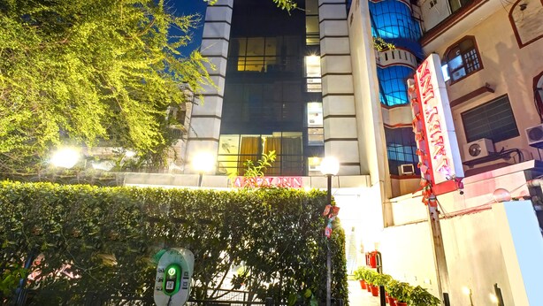 A hotel with a prominent sign, a modern facade, and a well-lit entrance.