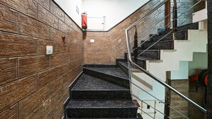 A staircase with a stone wall on one side and a glass railing on the other.