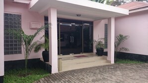 A building with a pink exterior, a glass door entrance, and steps leading to the door.