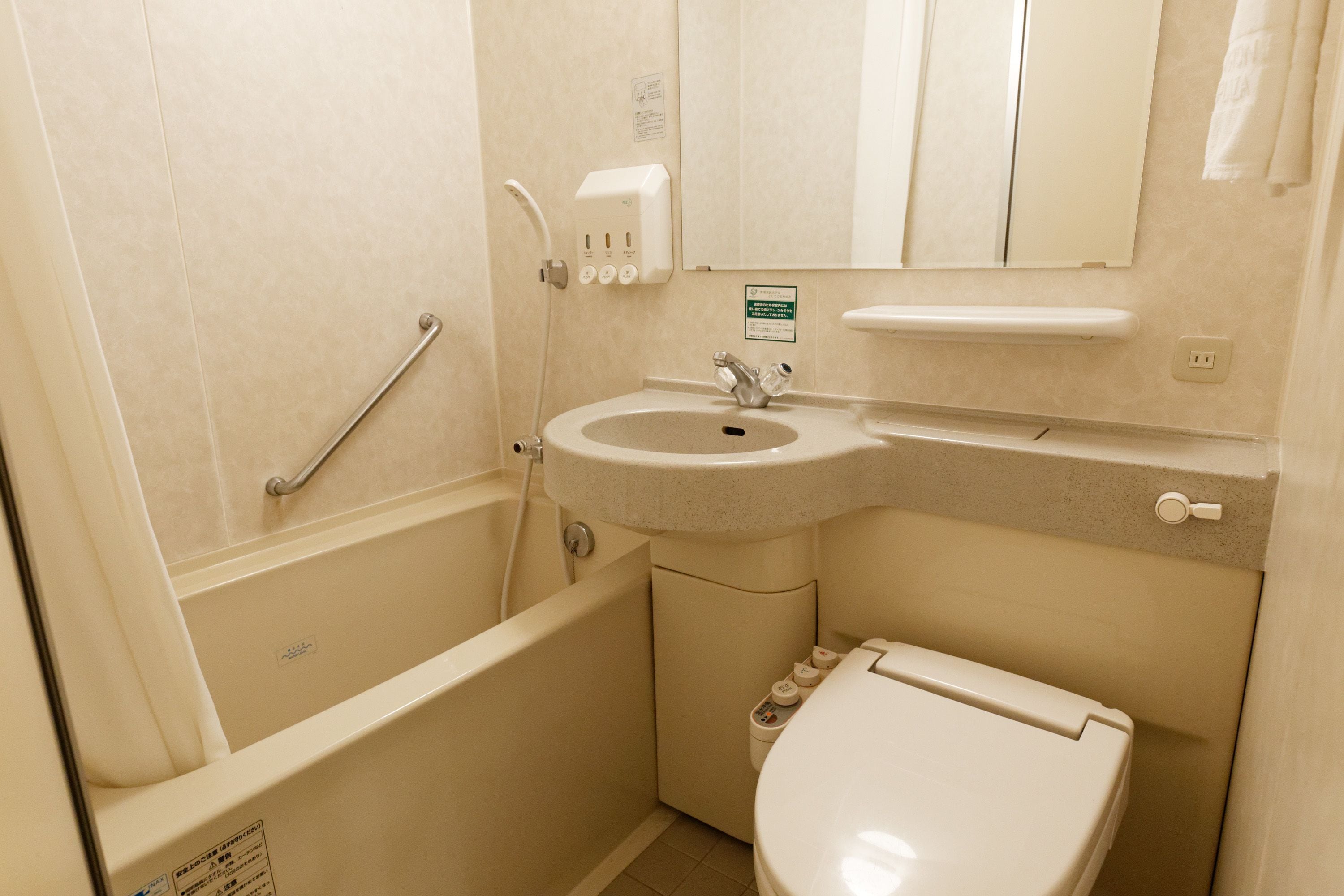 Un baño pequeño con bañera, lavabo e inodoro.