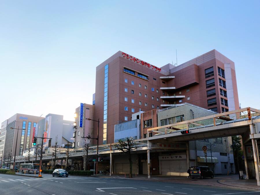 A multi-story building with a prominent red sign on the top.