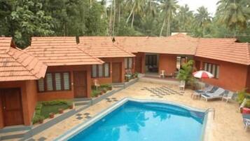 Relax by the resort's central pool surrounded by lush greenery and comfortable lounge chairs.