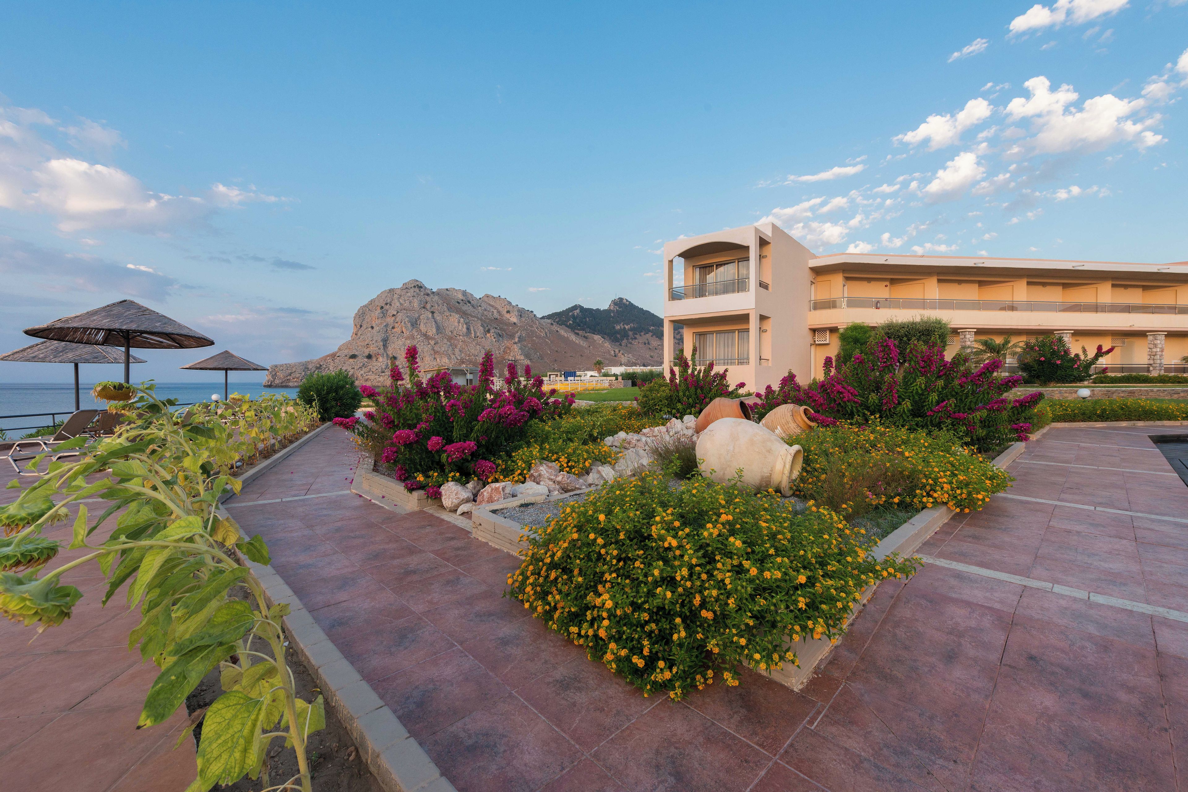 A resort with a pool area, a mountain backdrop, and a building with balconies.