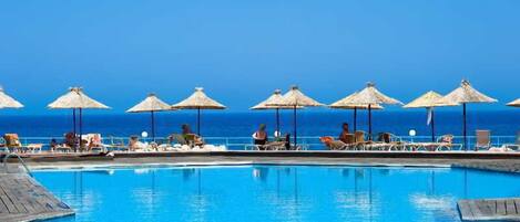 Piscine extérieure, parasols de plage, chaises longues