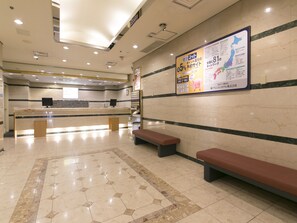 A spacious lobby with a reception desk, benches, and a large informational poster on the wall. - Okayama Washington Hotel Plaza (Okayama)