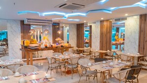 Un restaurant moderne avec des murs en marbre, des éléments décoratifs en bois et différents types de sièges, notamment des tables et des chaises.