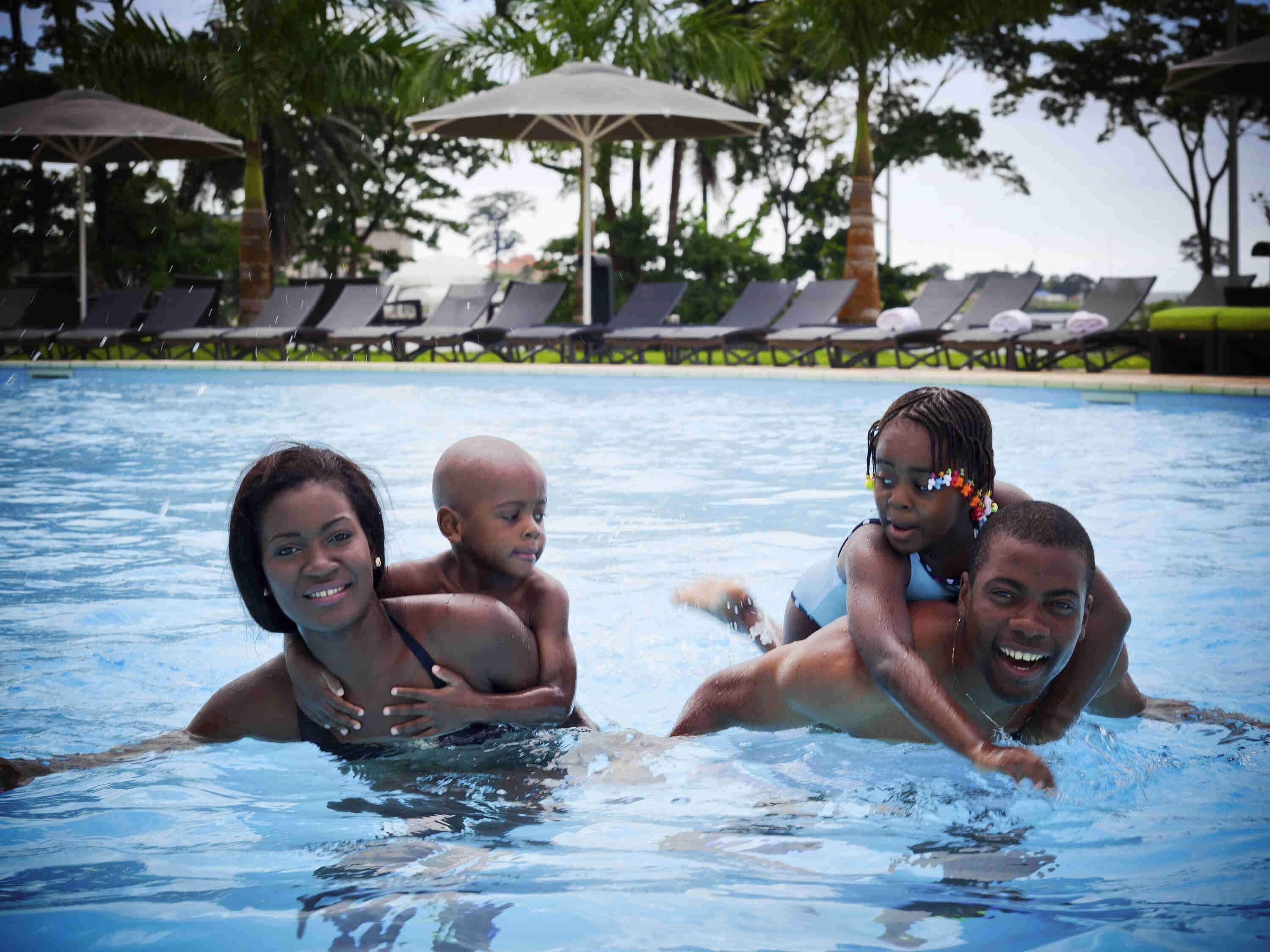 Alberca al aire libre, sombrillas en la alberca y camastros 